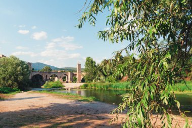 Bir yaz günü Besalu, Katalonya 'daki Fluvia Nehri üzerindeki taş köprü manzarası.