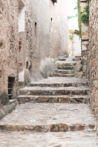 Stone steps up on a narrow street in an old European city in Spain.