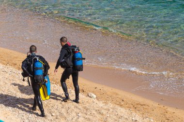 Tossa De Mar, İspanya - 4 Ağustos 2019: Deniz kenarındaki kumlu bir sahilde dalgıçlar ve dalış için hazırlanıyor