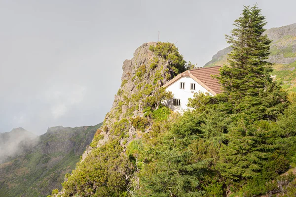 A white house with a tiled roof in the mountains among the clouds. — Stock Photo, Image