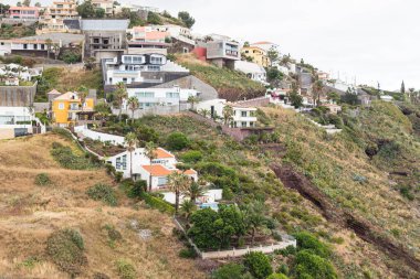 Bulutlu bir yaz gününde Madeira kıyısı ve Pontu de Garageu köyü manzarası.