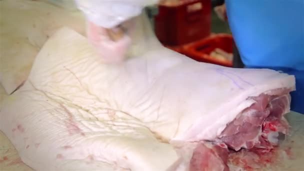 Працівник вирізав шматочок м'яса на виробництві — стокове відео