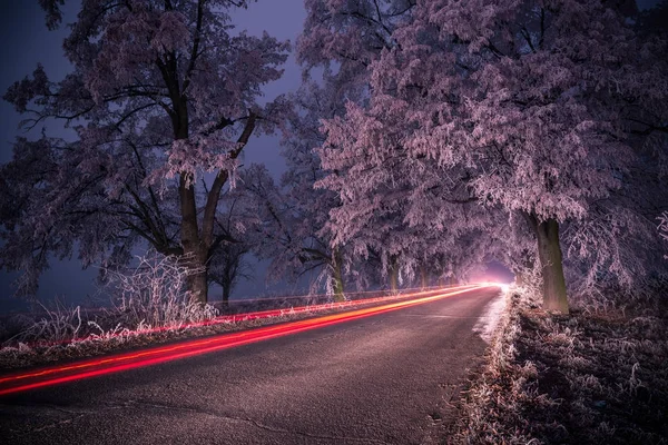 Light trails at night in winter, frozen road. — Stock Photo, Image