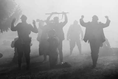 Silhouettes of Soldiers in uniforms during War with rifles on battlefield. All area is in smoke and sunrays peeking thru. There are hostages in the picture. clipart