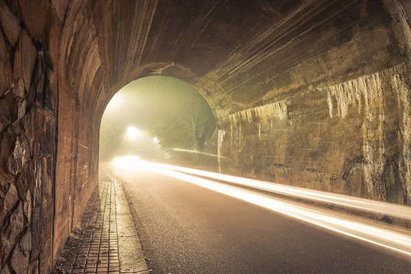 Le tunnel. Sortir avec le brouillard effrayant et le brouillard la nuit avec des sentiers loght de voiture . — Photo