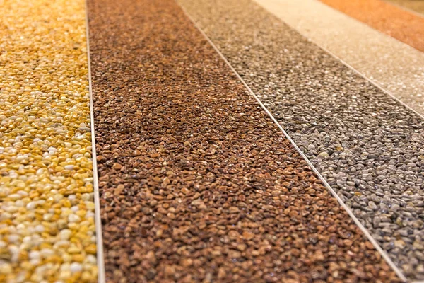 Zamknij naturalny kamienny dywan. Dekoracyjna powłoka kamienna. Odporne na poślizg wykończenie podłogi zawierające cząstki kamienia naturalnego. Zestaw różnych typów i kolorów. — Zdjęcie stockowe