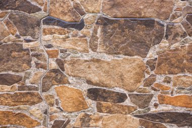 Çakıl taşı zemin ve duvar, arka plan dokuları. Sıcak renk tonları.