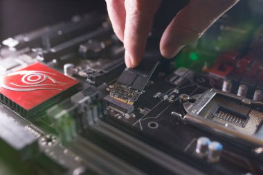 Ssd yuvasına odaklan, M2 tipi Nvme destekli, bilgisayar anakartlı. Teknisyen, SSSD olarak bilinen flaş çipli yeni bir yüksek kapasiteli sürücü yüklüyor..