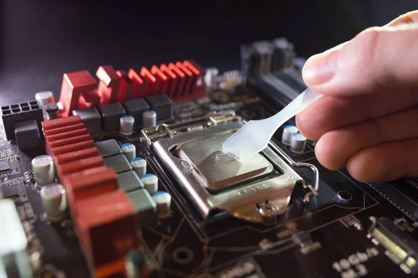 Aplicación de pasta térmica en el chip del procesador portátil para una refrigeración de alta calidad. Difusión de compuestos térmicos para mejorar el rendimiento de enfriamiento. Concepto de actualización o reparación de PC . — Foto de Stock