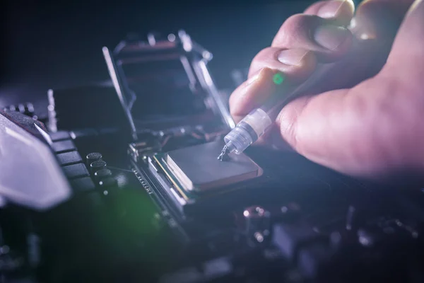 Close up to technician squeezing or application the thermal paste compound on the top of main cpu in the socket. Concept of repairing or upgrading computer hardware. — Stock Photo, Image