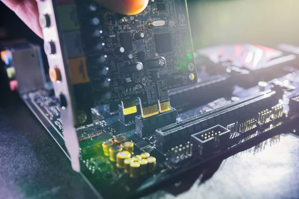 Tarjeta de sonido Proffesional siendo instalada en la placa base por el técnico de PC. Concepto de actualización o reparación de tarjetas de sonido PCI . — Foto de Stock