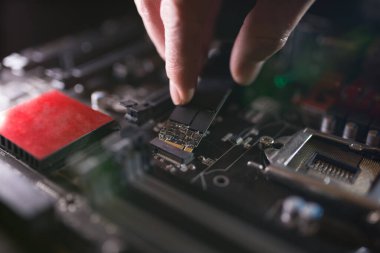 Ssd yuvasına odaklan, M2 tipi Nvme destekli, bilgisayar anakartlı. Teknisyen, SSSD olarak bilinen flaş çipli yeni bir yüksek kapasiteli sürücü yüklüyor..