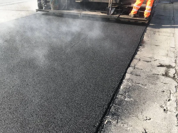 Lavoratore Con Tuta Riflettente Mentre Asfalta Una Strada — Foto Stock