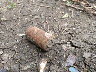 Yerde paslı pil var.