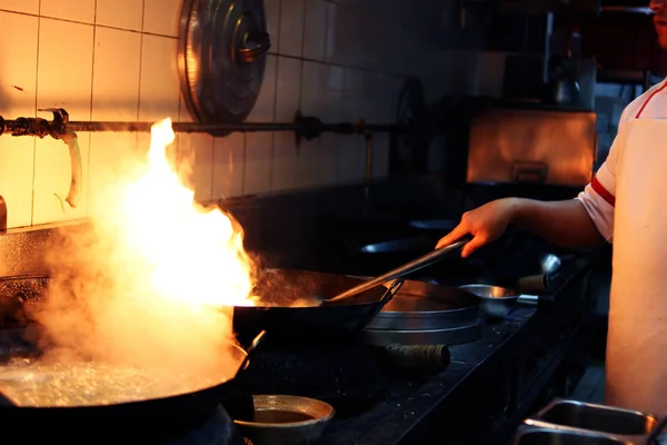 Chef is stirring cooking in work