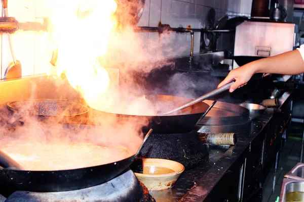 Chef is stirring cooking in work