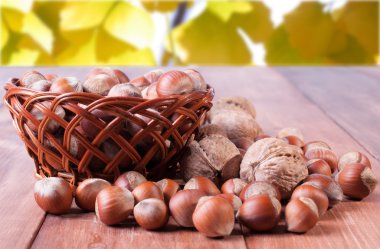 Sarı yaprakların bir arka plan üzerine bir sepet içinde fındık. Arka plan bulanık.