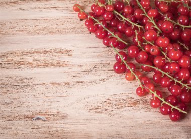 Olgun kırmızı kuş üzümü ahşap arka plan üzerinde meyveler