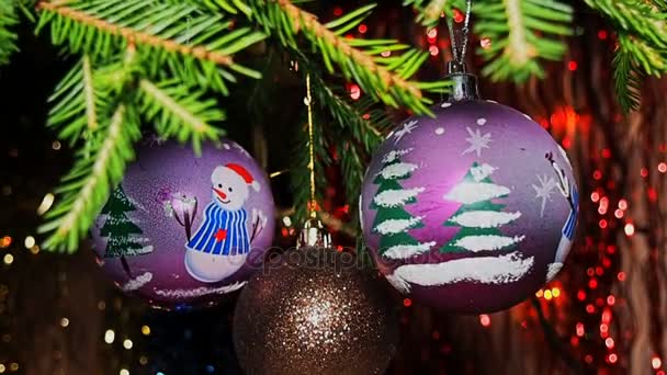 Decoraciones navideñas balanceándose en las ramas y guirnalda brillante sobre fondo borroso — Vídeos de Stock