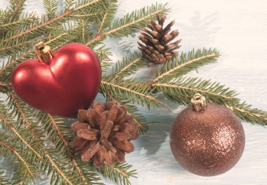 Noel ağacı dalı ahşap arka plan kalp ile Noel top ve çam kozalakları