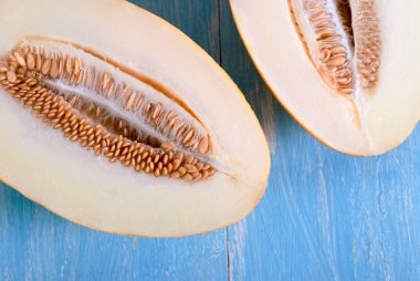 Ahşap arka plan üzerinde olgunlaşmış kavun yarısı dilimlenmiş