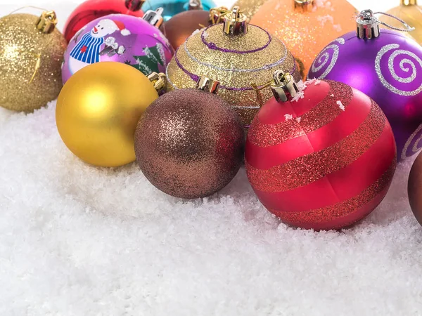 Un tas de boules de Noël colorées dans la neige . — Photo