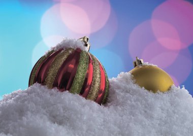 Rüzgârla oluşan kar yığını bir bokeh arka plan üzerinde Noel topları