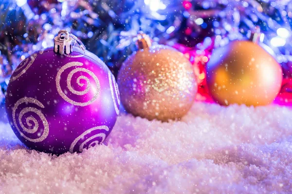 Різдвяні кульки на снігу. фон розмитих гілок — стокове фото