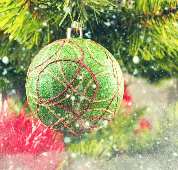 Christmas tree ball on a branch among tinsel — Stock Photo, Image