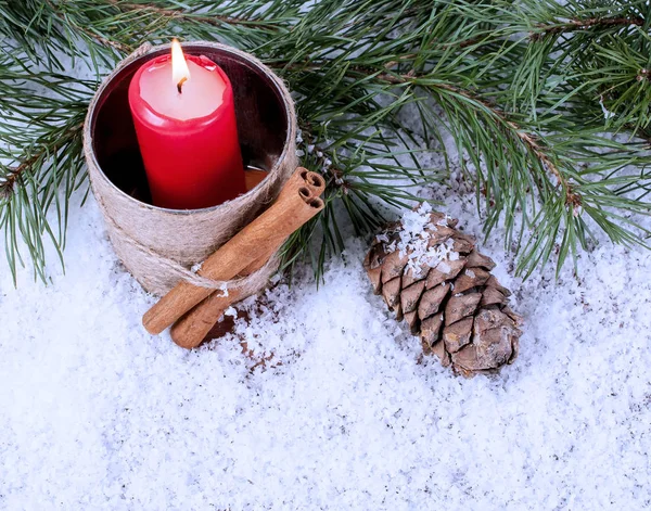 Свеча, ель и комок на снегу — стоковое фото