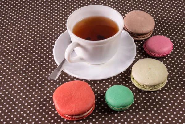 Французские разноцветные пирожные с макаронами и чашкой чая — стоковое фото