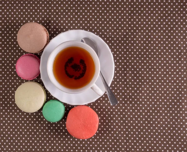 Bunte französische Macarons mit Tasse Tee auf dem Tisch. Ansicht von oben — Stockfoto