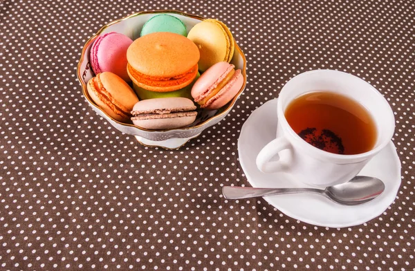 Tasse Tee und ein Teller mit bunten französischen Makronen auf einem Tisch mit Kopierraum — Stockfoto