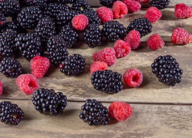 Ahşap arka planda taze meyve ahududu ve böğürtlen karışımı..