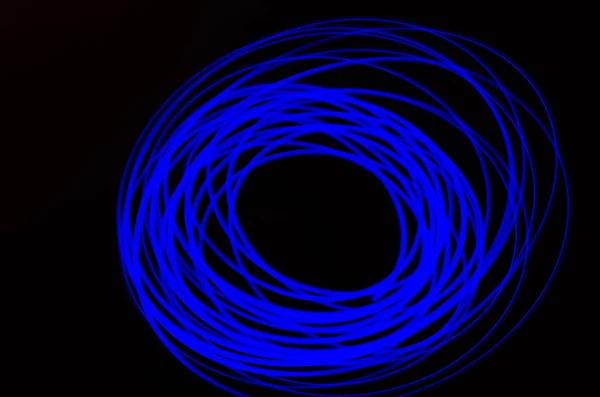 Linhas espirais e azuis claras em um fundo preto — Fotografia de Stock