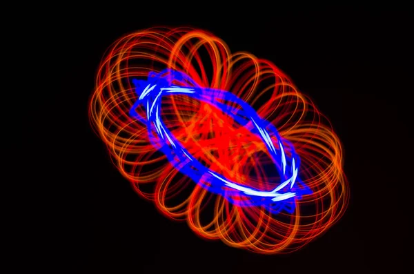 Espiral claro, linhas vermelhas e azuis em um fundo preto — Fotografia de Stock