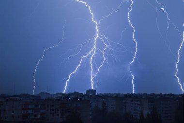 Yıldırım şehrin gece gökyüzünde üzerinde Evin çatısı