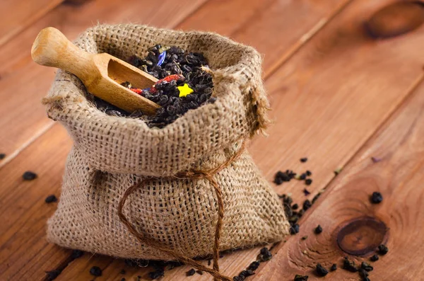 Té verde en un saco con una pala sobre una mesa de madera —  Fotos de Stock