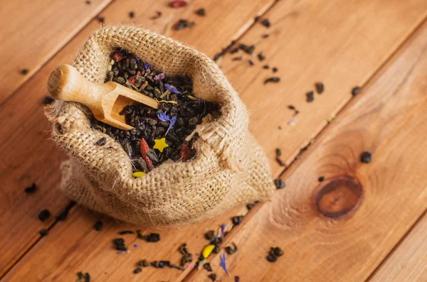 Té verde en un saco con una pala sobre una mesa de madera —  Fotos de Stock