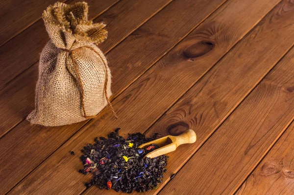 Té verde en un saco con una pala sobre una mesa de madera —  Fotos de Stock