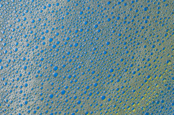 Бульбашки піни на синьо-жовтій текстурі тла — стокове фото