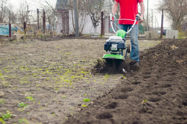 Mann arbeitet im Frühlingsgarten mit Pinne — Stockfoto