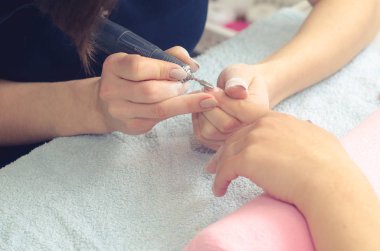 Asıl manikür için makinasıyla manikür çivi hazırlar