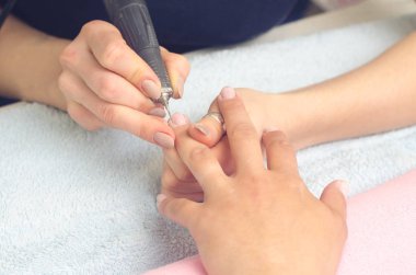 Asıl manikür için makinasıyla manikür çivi hazırlar