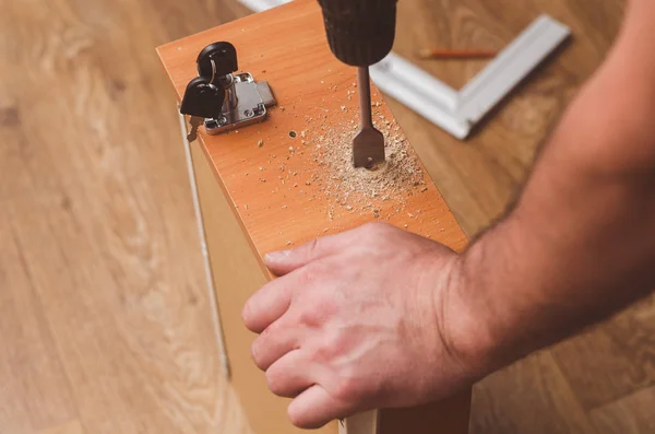 Drilling holes with a drill to install a mortise lock — Stock Photo, Image