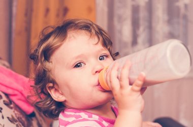 Küçük kız bir şişe süt içiyor