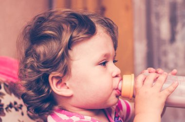 Küçük kız bir şişe süt içiyor