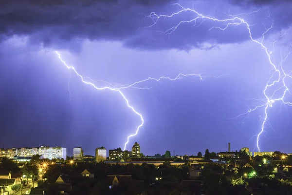 Lightning over the city in the night sky strikes the roof of the house — Stock Photo, Image