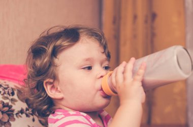 Küçük kız bir şişe süt içiyor