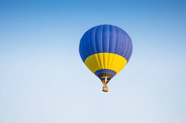 Colorido de balão de ar quente com fundo de fogo e céu azul — Fotografia de Stock